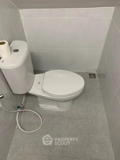 Compact bathroom with modern toilet and tiled walls, ideal for small spaces.