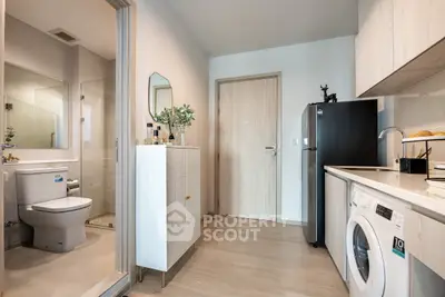 Modern apartment with compact kitchen and bathroom, featuring sleek appliances and stylish decor.