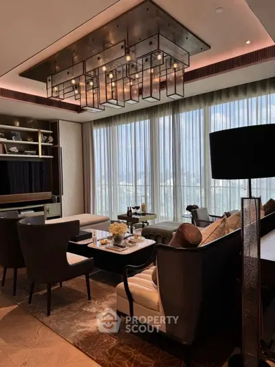 Luxurious living room with modern chandelier and elegant furnishings in high-rise apartment.