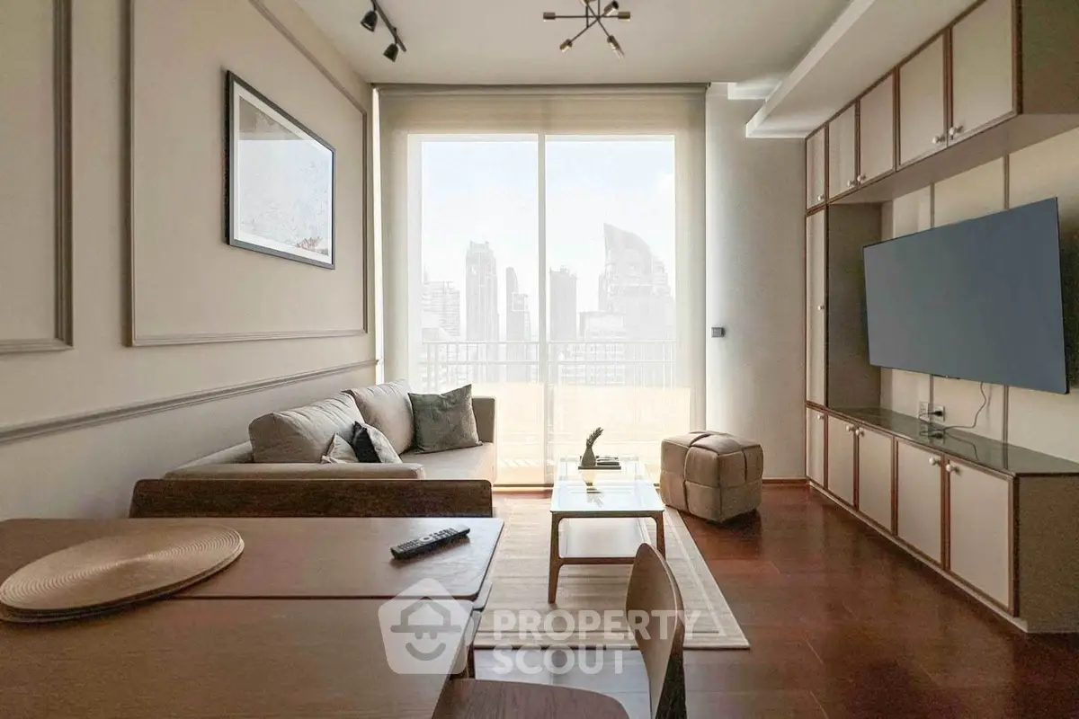 Modern living room with city view, stylish furniture, and large TV setup.