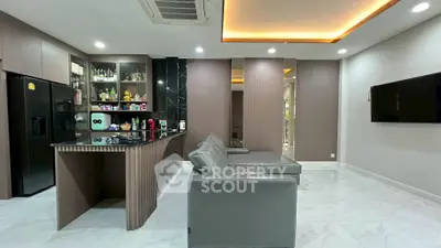 Modern living room with sleek leather sofas and stylish open kitchen layout