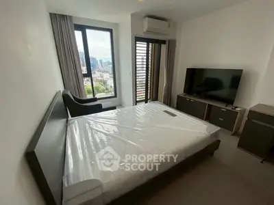 Modern bedroom with city view, featuring a large window, air conditioning, and a flat-screen TV.