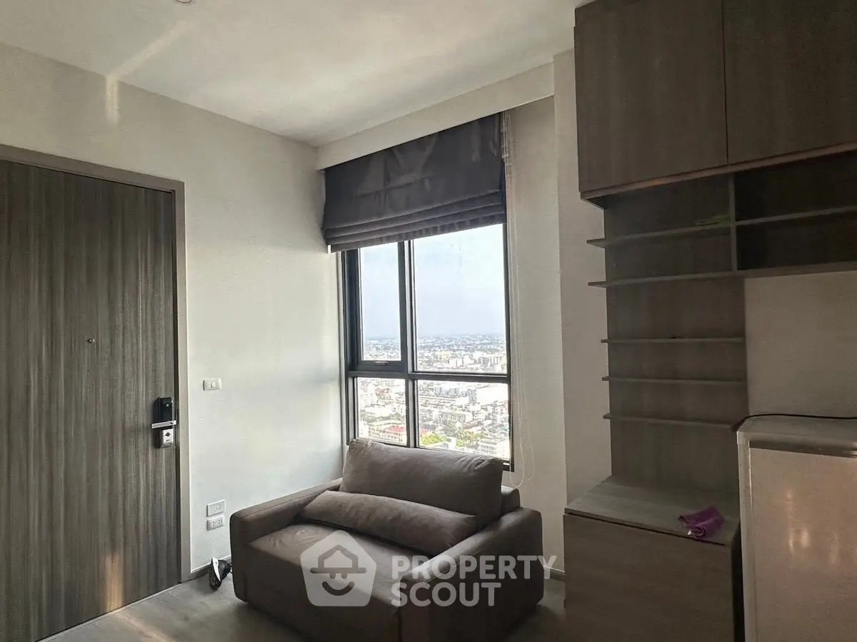 Modern apartment interior with city view, featuring cozy sofa and built-in storage.