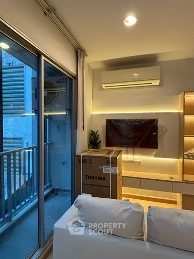 Modern living room with balcony, featuring air conditioning and stylish lighting.
