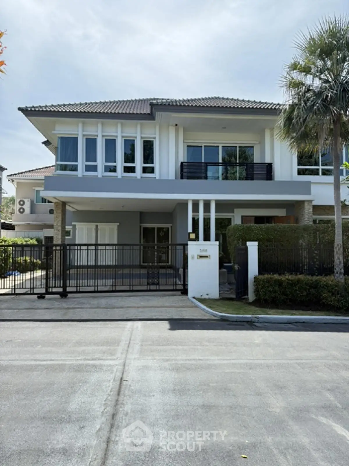 Elegant modern two-story house with large windows and landscaped front yard in a serene neighborhood.