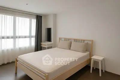 Modern minimalist bedroom with natural light and sleek furniture design.