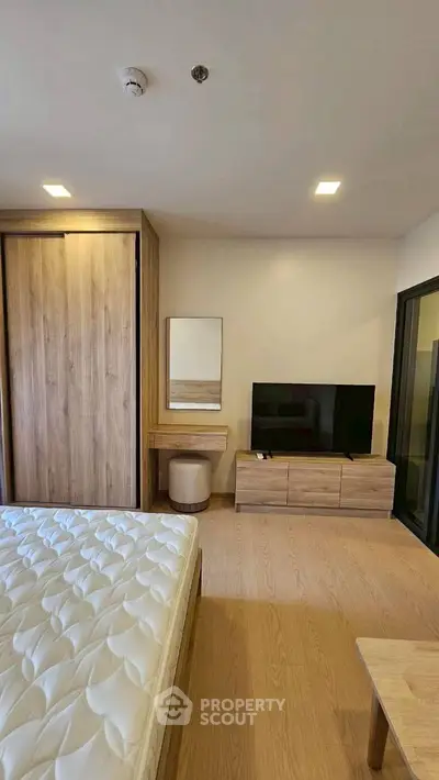 Modern bedroom with wooden furniture and TV, featuring a cozy ambiance and ample storage space.