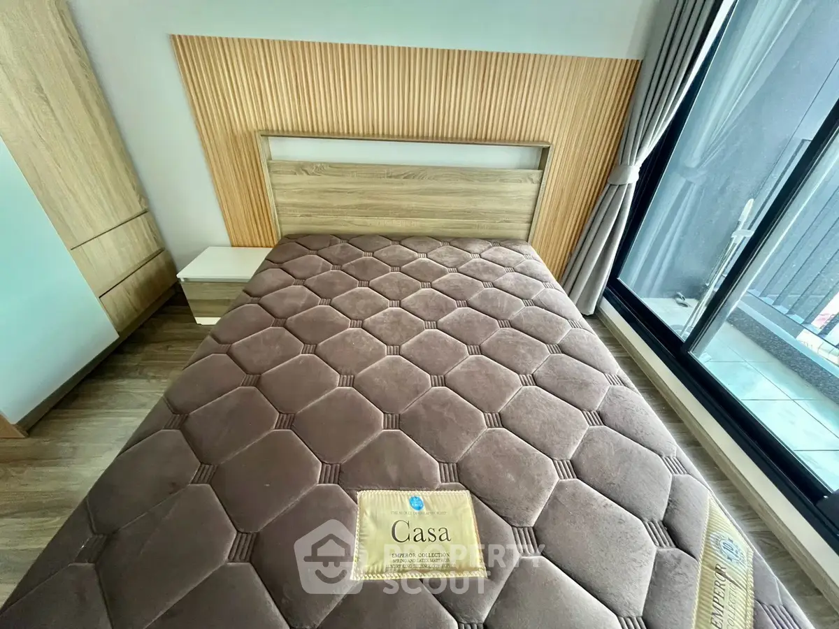 Modern bedroom with stylish wooden headboard and large window view