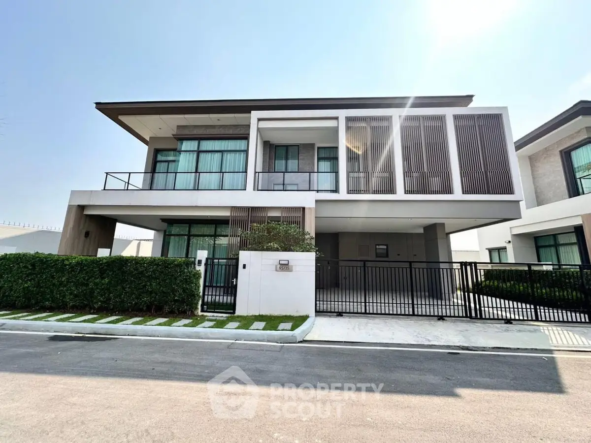 Modern two-story house with sleek design and large windows in a suburban neighborhood.