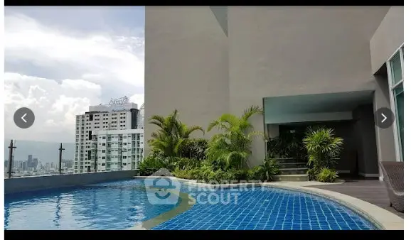 Luxurious rooftop pool with stunning city views and lush greenery, perfect for relaxation and leisure.