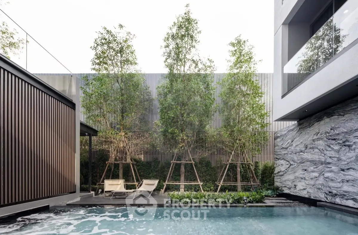 Luxurious modern pool area with sleek design and lush greenery