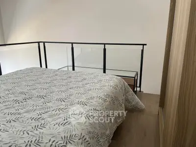 Cozy bedroom with modern railing and stylish bedding in a contemporary home.