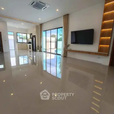Spacious modern living room with sleek tile flooring and open kitchen layout.