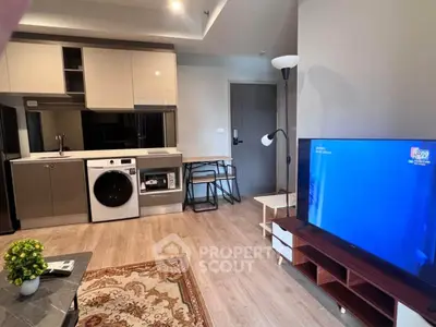 Modern studio apartment with open kitchen and living area, featuring a washing machine and stylish decor.