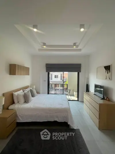 Spacious modern bedroom with balcony access and stylish decor