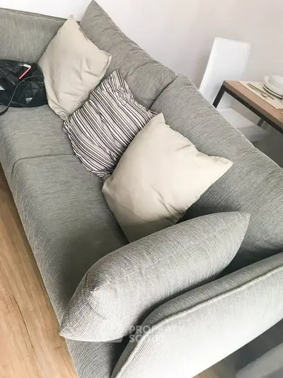 Modern living room with stylish gray sofa and cozy cushions, perfect for relaxation.