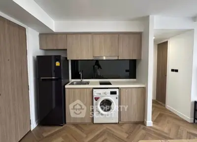 Modern kitchen with integrated washing machine and sleek wooden cabinetry.