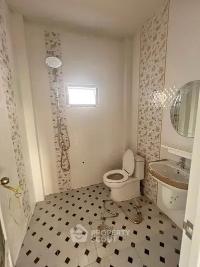 Cozy bathroom with floral tiles and modern fixtures in a bright real estate property.