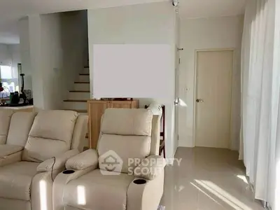 Spacious living room with plush recliners and natural light