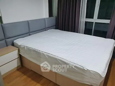 Spacious bedroom with large bed and modern decor, featuring wooden flooring and ample natural light.