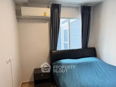 Cozy bedroom with modern air conditioning and stylish bed near window.
