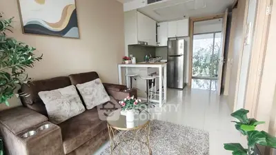 Modern living room with cozy sofa and stylish kitchen in open layout apartment.