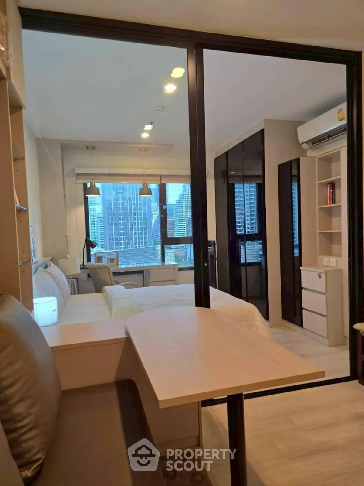 Modern apartment interior with city view, featuring a cozy living area and sleek furnishings.