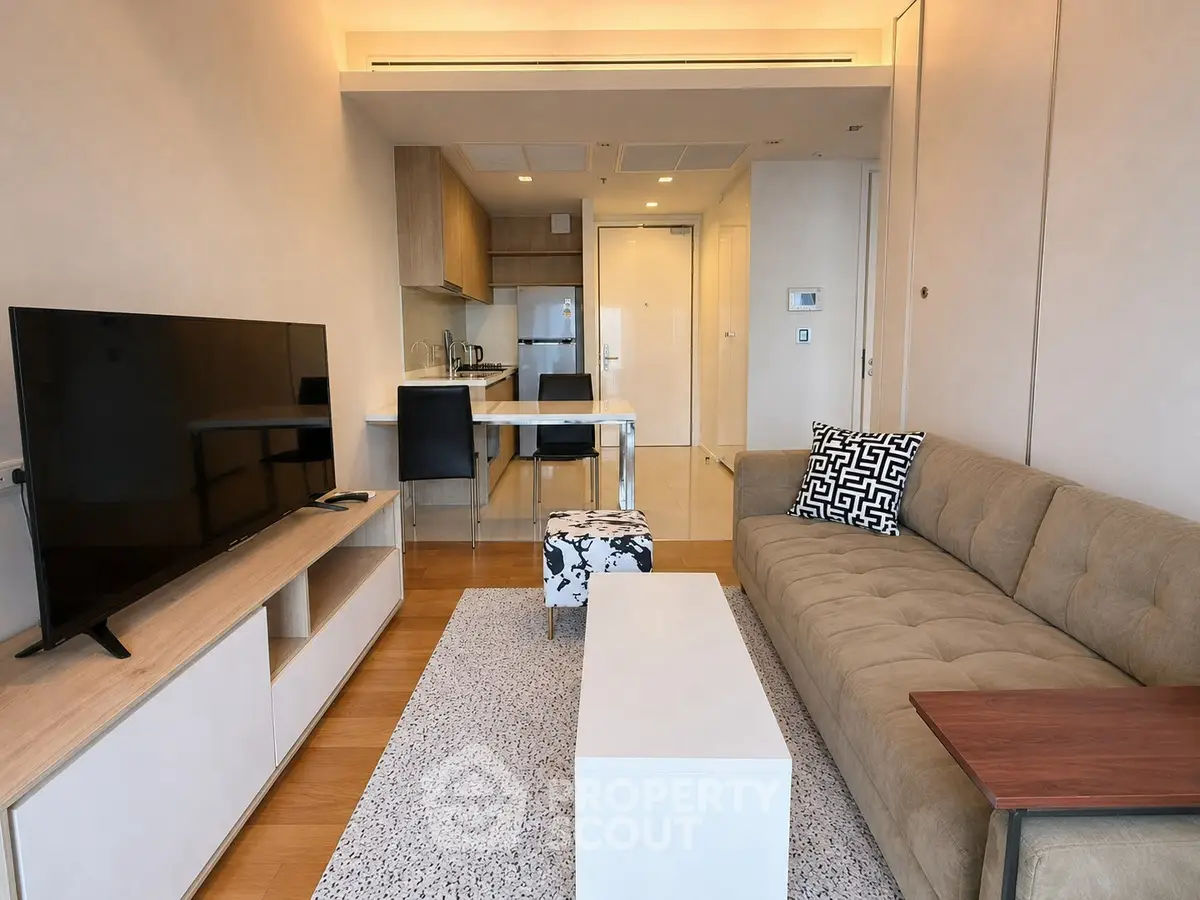 Modern living room with open kitchen, stylish decor, and cozy seating area in a contemporary apartment.