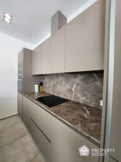 Modern kitchen with sleek cabinetry and marble backsplash