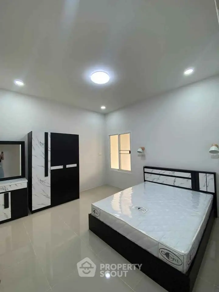 Modern bedroom with sleek furniture and ample natural light.