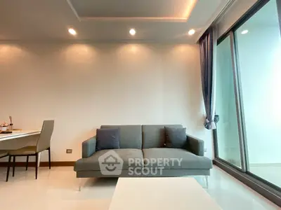 Modern living room with sleek sofa and large window offering natural light.
