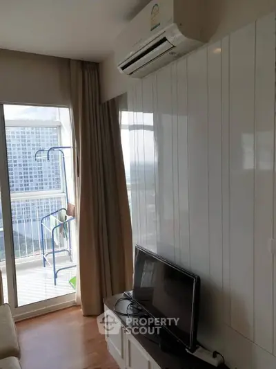 Modern living room with air conditioning and balcony view in high-rise apartment.