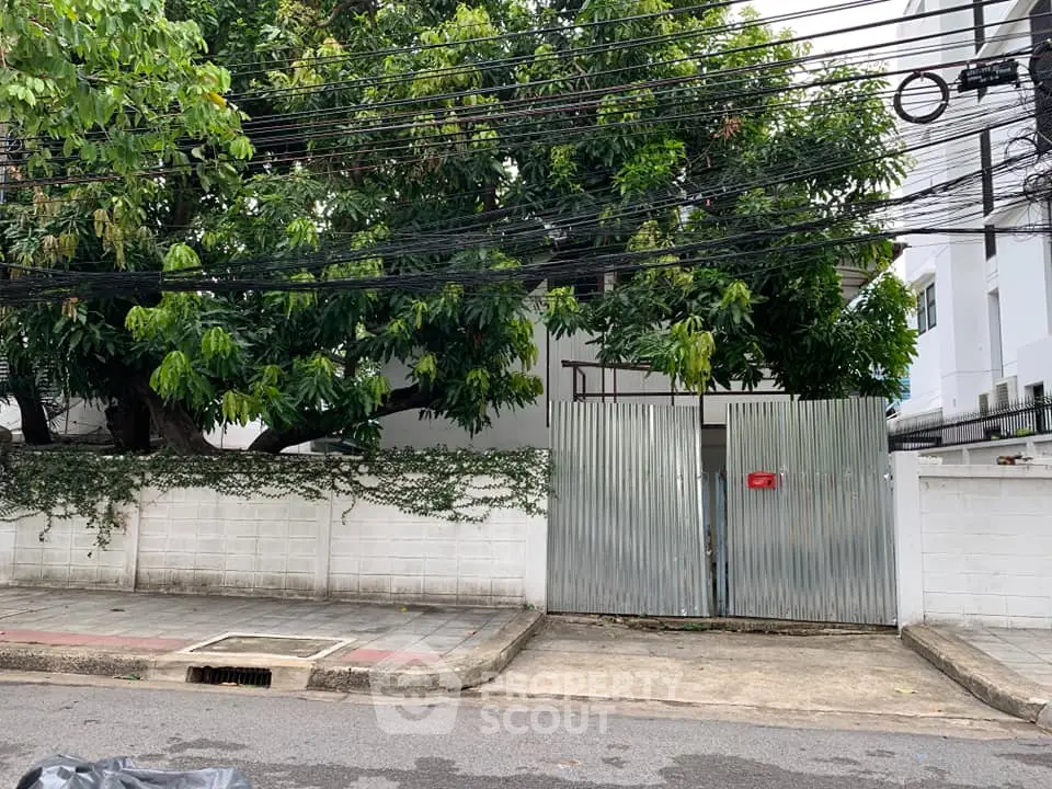 Charming urban property with lush greenery and secure gated entrance.