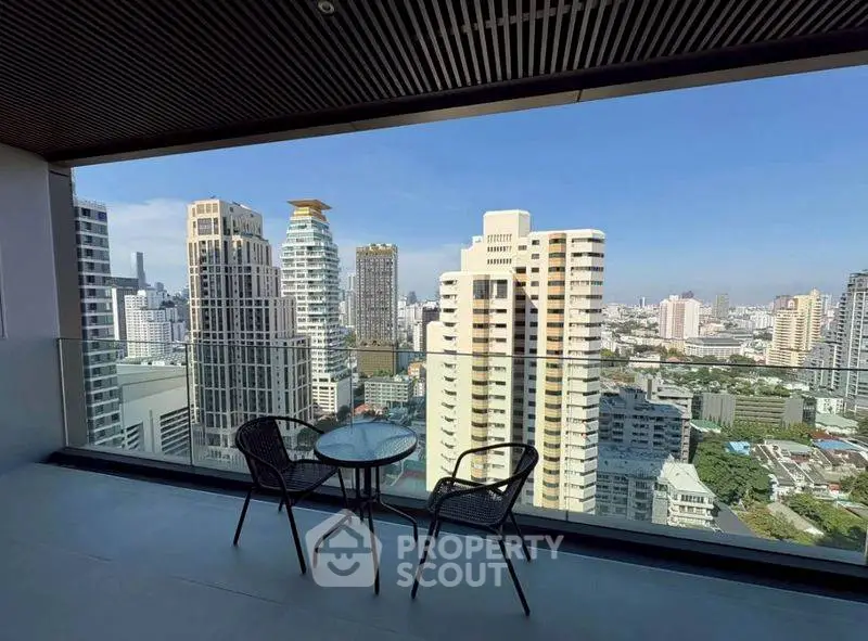 Stunning cityscape view from a high-rise balcony with modern seating, perfect for urban living.