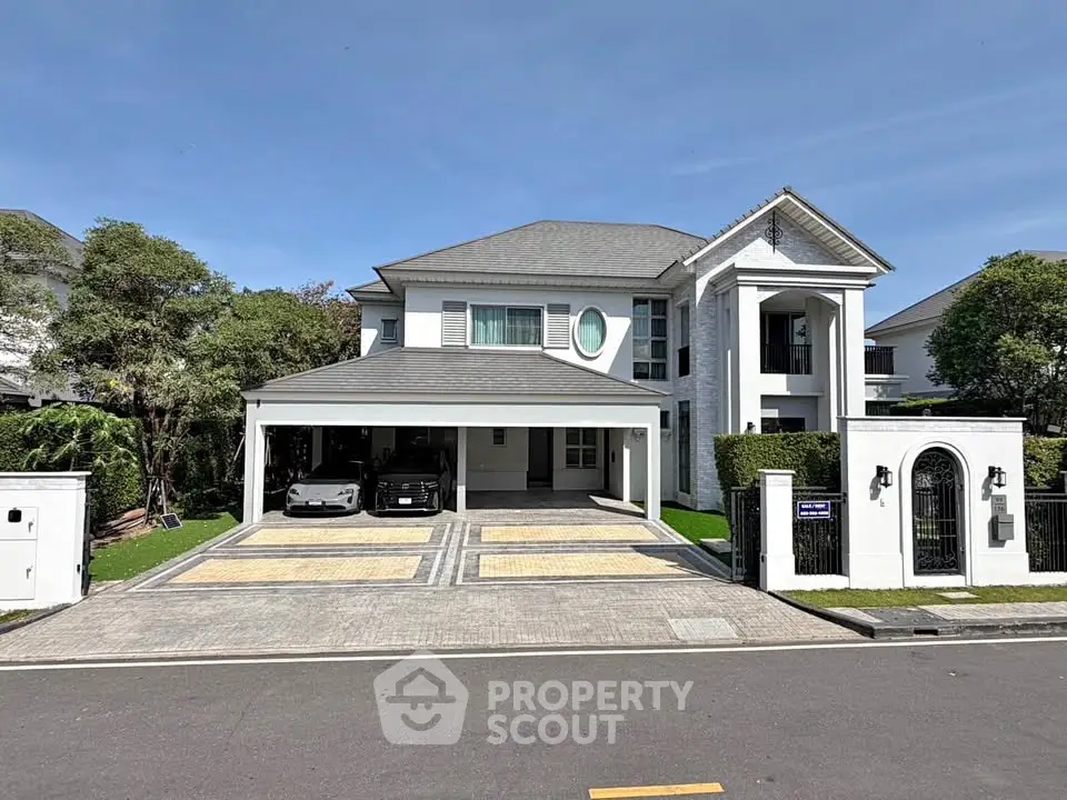 Luxurious modern house with spacious driveway and elegant facade in a serene neighborhood.