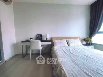 Spacious bedroom with modern decor and natural light, featuring a cozy bed and stylish desk area.
