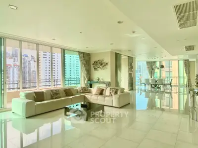 Luxurious open-plan living room with stunning city views and elegant furnishings.