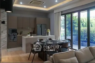 Modern open-layout kitchen and dining area with large windows and garden view.