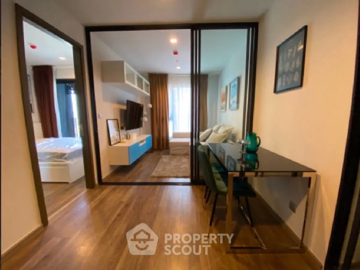 Modern apartment interior with stylish living room and study area, featuring wooden flooring and elegant decor.