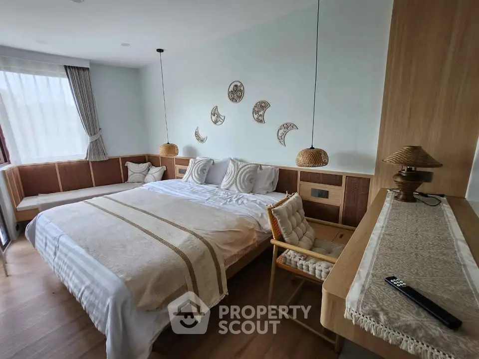 Cozy bedroom with modern decor, featuring a large bed, stylish lighting, and natural wood accents.