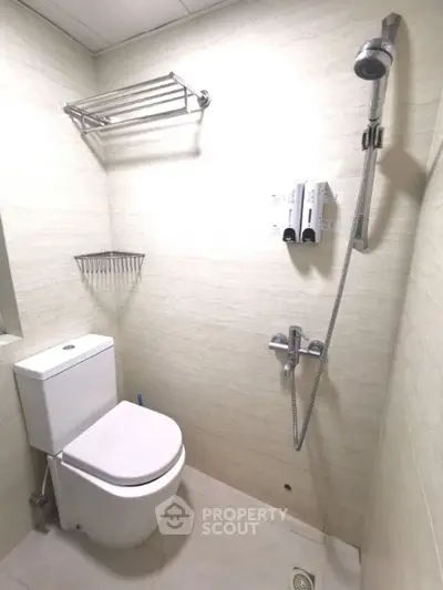 Modern bathroom with sleek shower and toilet in minimalist design.