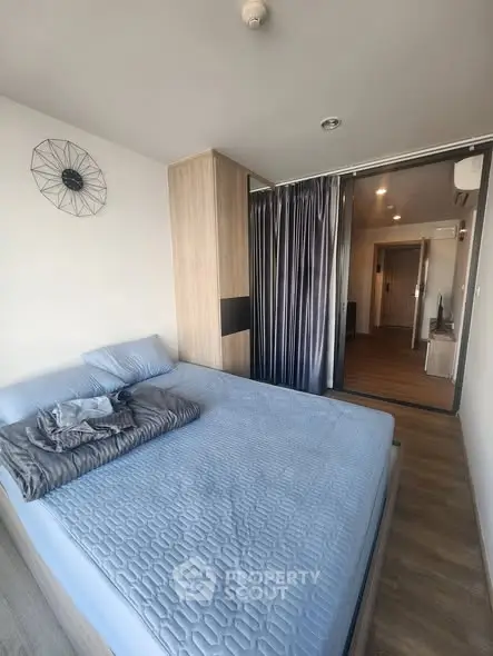 Modern bedroom with stylish decor and sliding glass doors in a contemporary apartment.