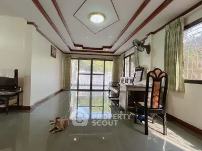 Spacious living room with elegant ceiling design and large windows for natural light.