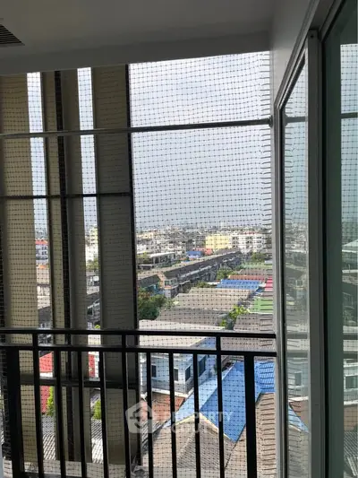 High-rise balcony with safety netting offering panoramic city views.