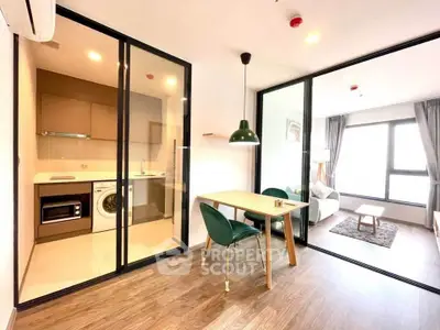 Modern apartment with open layout, featuring a stylish kitchen and cozy living area with large windows.