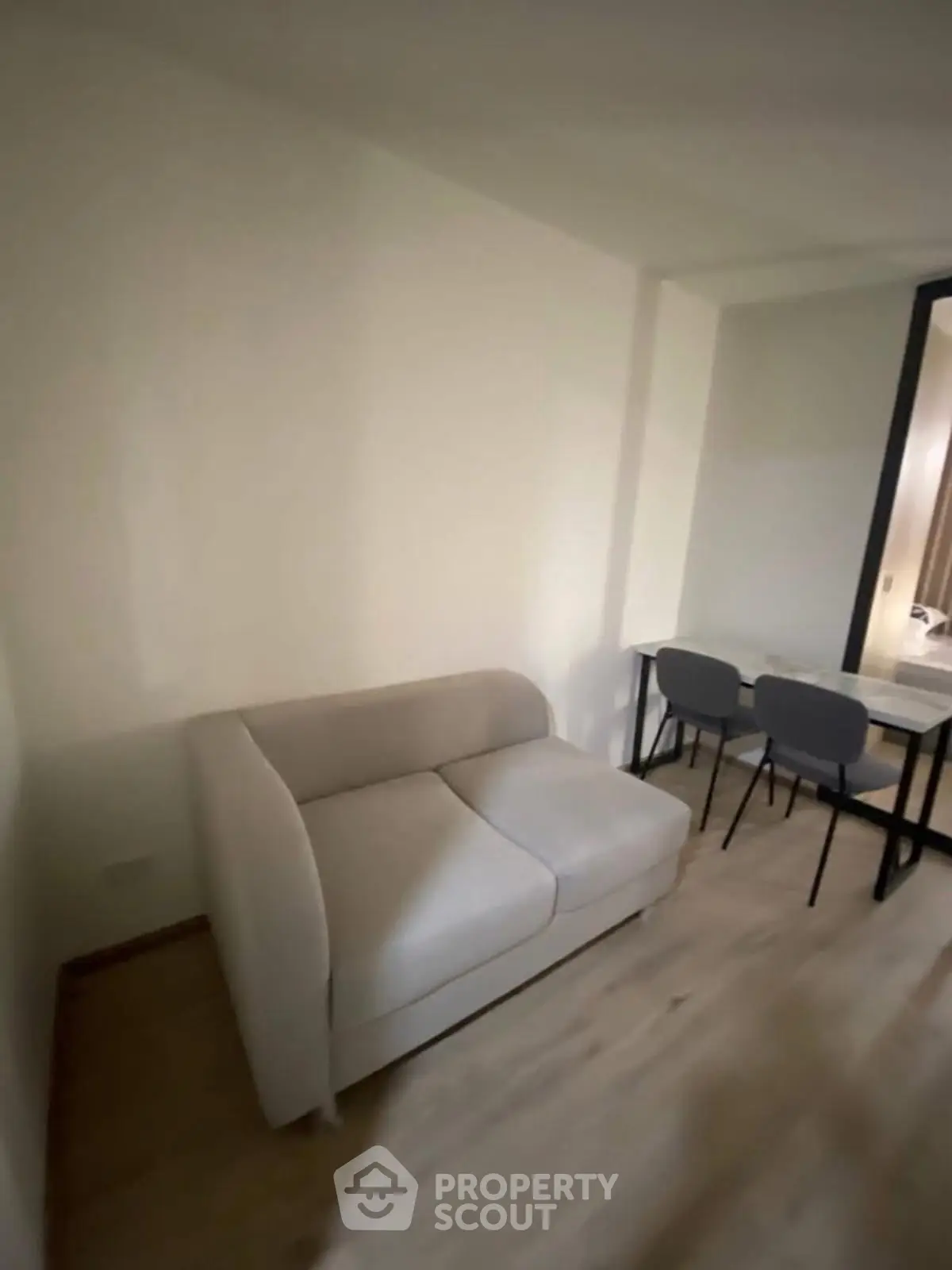 Cozy small living area with modern sofa and dining table in compact apartment.