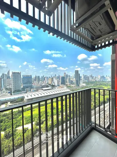 Stunning cityscape view from modern balcony overlooking lush greenery and skyline.