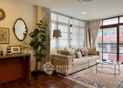 Elegant living room with large windows, cozy sofa, and stylish decor in a bright, inviting space.