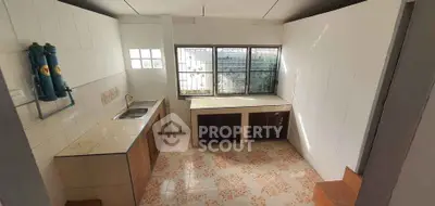 Cozy kitchen with tiled countertops and large window for natural light
