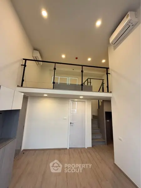 Modern loft apartment with high ceilings and mezzanine level, featuring sleek design and ample natural light.